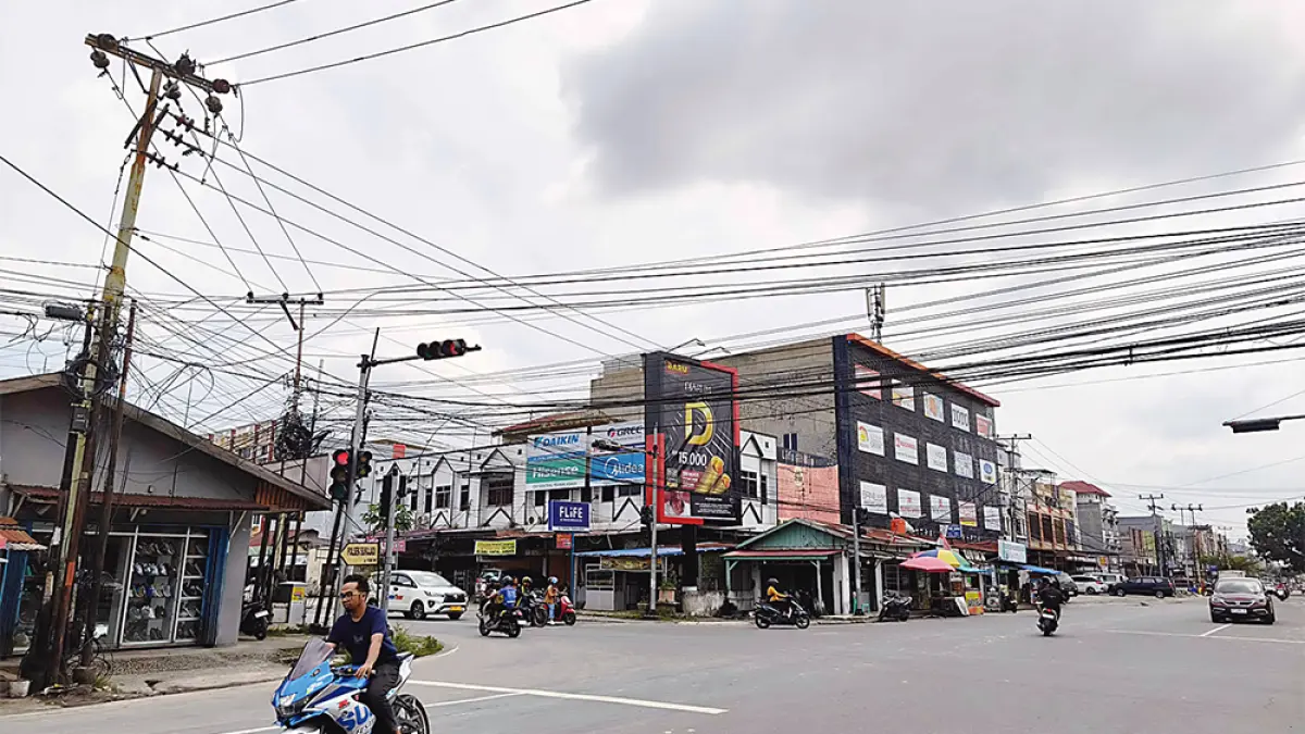 SEMRAWUT: Kondisi kabel fiber optik (FO) yang dipasang semrawut di Jalan Durian  simpang Jalan Rajawali, Kecamatan Sukajadi. Foto diambil Rabu (22/7/2026). (EVAN GUNANZAR/RIAU POS)