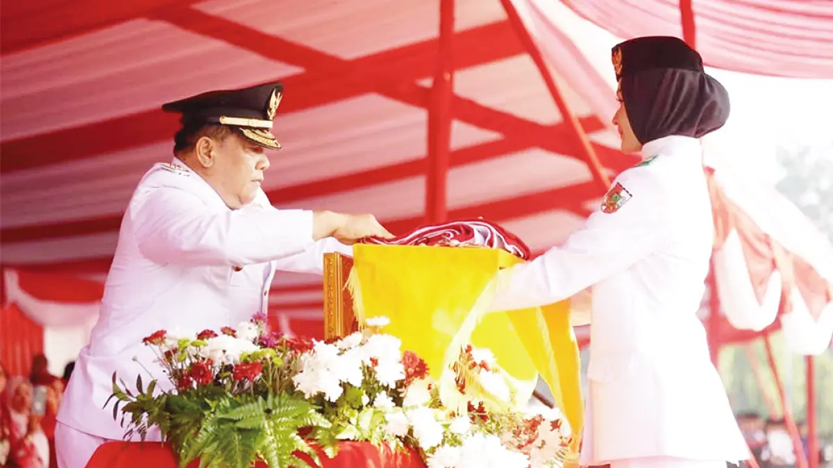 SERAHKAN BENDERA: Pelaksana Tugas Gubernur Riau SF Hariyanto menyerahkan bendera yang akan dikibarkan pada upacara peringatan HUT ke-81 Kemerdekaan RI di Halaman Kantor Gubernur Riau, Senin (17/8/2026). (Diskominfotik Riau untuk Riau Pos)