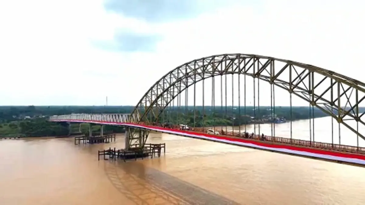 DIPASANGI BENDERA: Merayakan HUT ke-81 Kemerdekaan Republik Indonesia, bendera Merah Putih sepanjang 1.081 meter dipasang di Jembatan Rumbai, Kecamatan Kempas dan Tempuling, Kabupaten Inhil, Selasa (18/8/2026). (WARGA UNTUK RIAU POS)