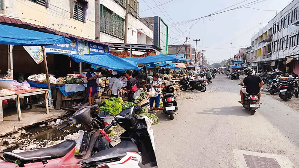 JALAN TERATAI: Para pedagang tetap bertahan berjualan di pinggir Jalan Teratai yang sedang dalam tahap perbaikan drainase dan badan jalan, Selasa (18/8/2026). (EVAN GUNANZAR/RIAU POS)