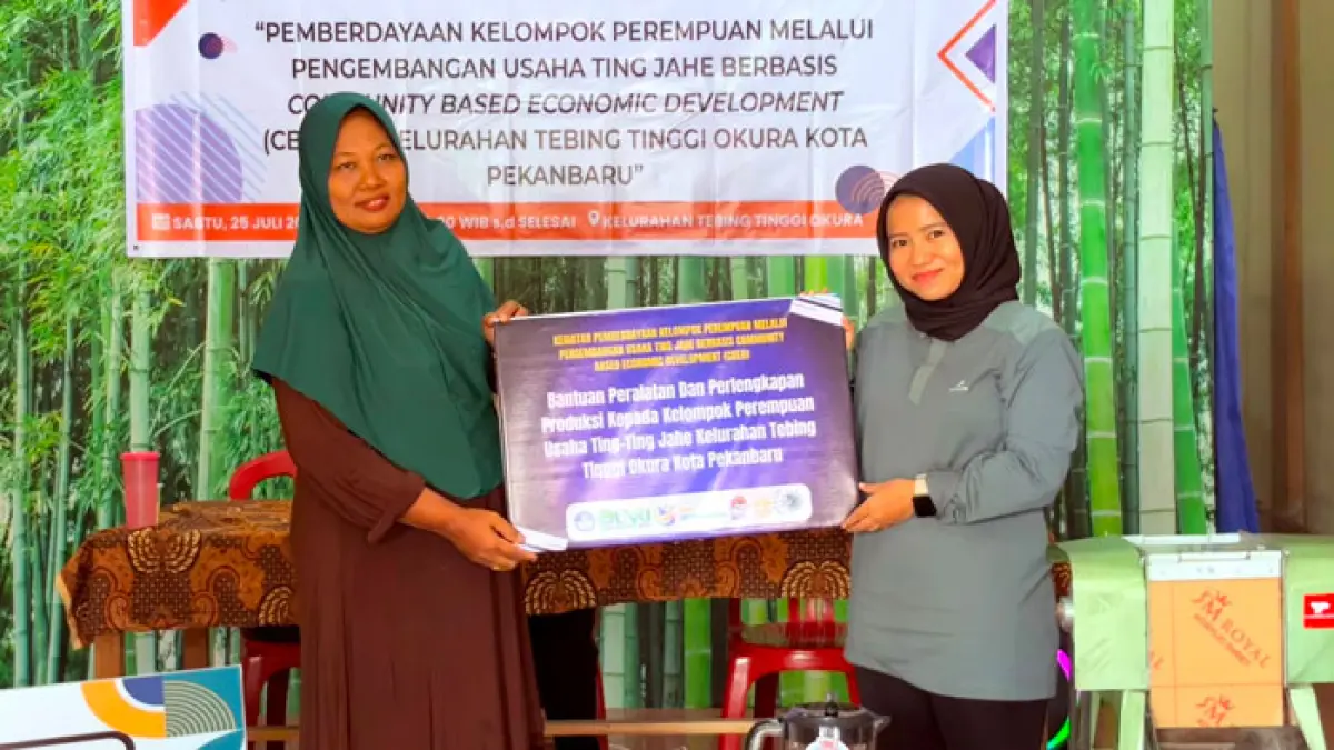Ketua Tim Program PkM Unri Risky Arya Putri SSos MSi serahkan hibah peralatan produksi secara simbolis kepada Ketua Kelompok Perempuan UMKM Ting Jahe di Tebing Tinggi Okura, Pekanbaru, Sabtu (25/7/2026) lalu. (Tim PkM Unri untuk Riaupos.co)