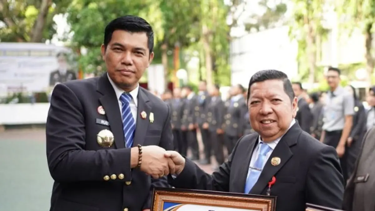 SERAHKAN PENGHARGAAN: Kepala Kantor Wilayah Kementerian Hukum Provinsi Riau, Rudy Hendra Pakpahan (kiri) menyerahkan penghargaan kepada Asisten I Setdaprov Riau Zulkifli, Rabu (19/8/2026). (Diskominfo Riau untuk Riau Pos)