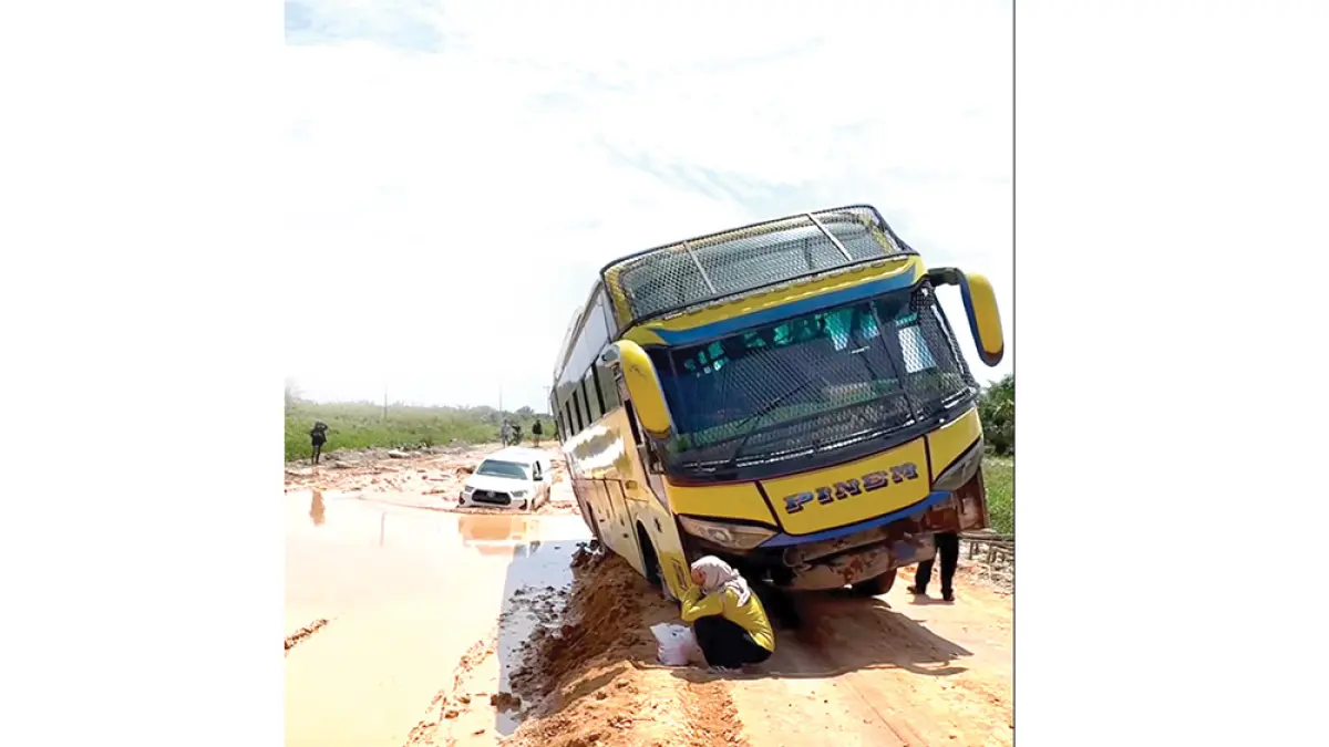  Bus Pinem yang membawa penumpang tergelincir saat melewati jalan Sontang-Duri, Kamis (20/8/2026). Tampak kendaraan lain mencoba melewati jalan yang kembali digenangi air berlumpur setelah diguyur hujan.(Warga Sontang untuk Riau Pos)