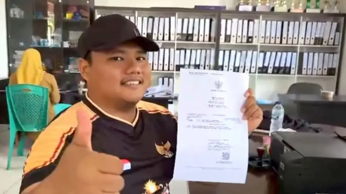 Kades Rambah Muda Kecamatan Rambah Hilir Rian Denny Setiawan SIp menunjukkan Akte Kelahiran yang telah dicetak langsung di desa melalui inovasi TANJAK Disdukcapil Rohul, baru-baru ini. (Disdukcapil Rohul untuk Riaupos.co)