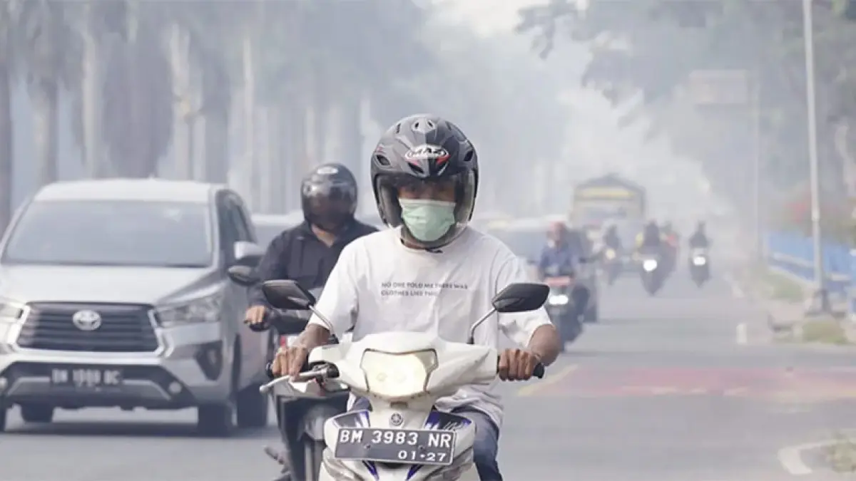 Pengendara sepeda motor memakai masker ketika melintas di Jalan Jenderal Sudirman, Pekanbaru yang diselimuti kabut asap, baru-baru ini. (Dok.Riau Pos)