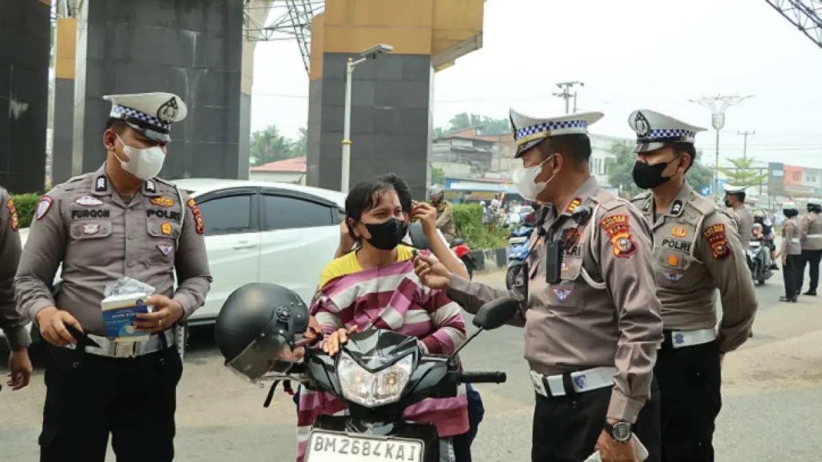 Satlantas Polres Kuansing membagi-bagikan masker pada pengendara di ruas jalan Proklamasi Kecamatan Kuantan Tengah, Senin (24/8/2026) siang. 9Istimewa)