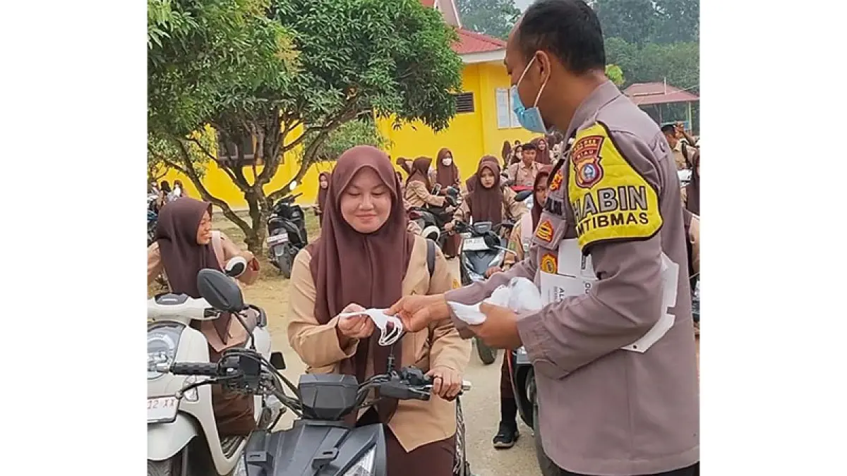 Personel Polsek Pangean membagi-bagikan masker pada siswa SMAN 1 Pangean, Rabu (26/8/2026). Foto Polsek Pangean
