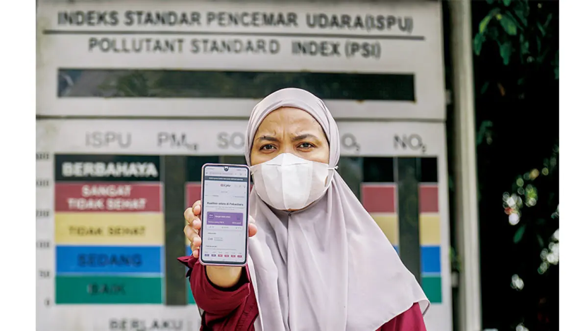 Warga memperlihatkan kualitas udara di Pekanbaru yang berstatus Sangat Tidak Sehat di ponselnya dengan latar papan ISPU dalam keadaan mati di depan Mal Pelayanan Publik Kota Pekanbaru, Selasa (25/8/2026).(MHD AKHWAN/RIAU POS)
