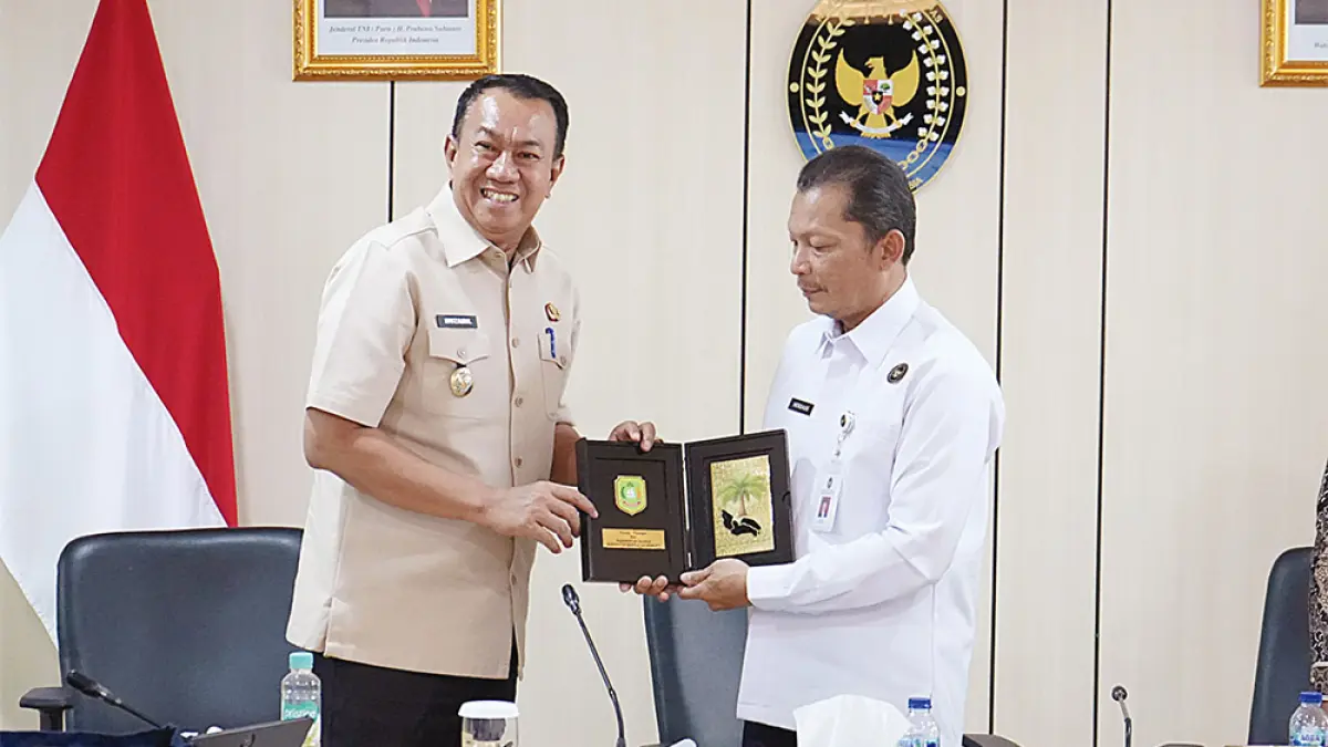 Wakil Bupati Kepulauan Meranti Muzamil Baharudin SM MM (kiri) menyerahkan cendera mata kepada Asisten Deputi Koordinasi Kerja Sama Kelembagaan Keimigrasian dan Pemasyarakatan Herdaus (kanan), usai rapat di kantor Kemenko Kumham Imipas RI, Jakarta, Rabu (26/8/2026). (diskominfotik meranti untuk riau pos)
