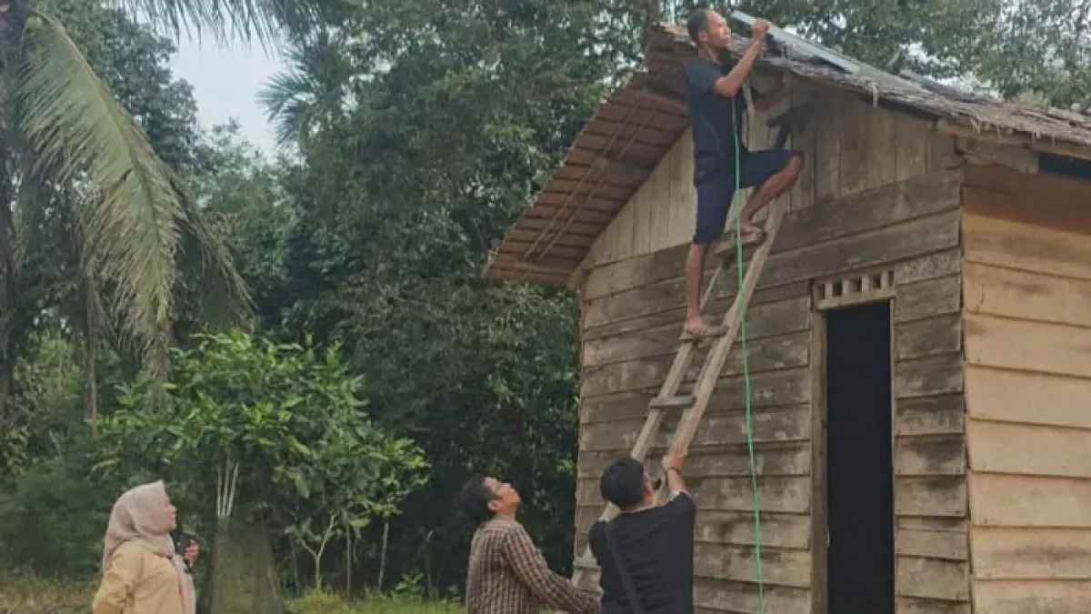 Kepala Dinsos Inhu, Rika Varia Nora (kiri) saat menyaksikan pemasangan penerangan di salah satu rumah warga, baru-baru ini. (Dinsos Inhu untuk Riaupos.co)