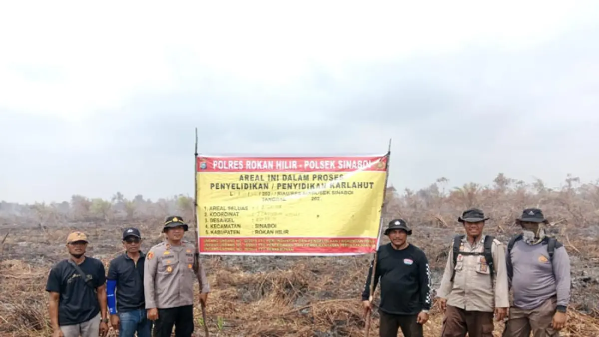 Personel Polsek Sinaboi meletakan spanduk berisi peringatan bahwa lahan bekas karhutla tersebut dalam proses penyidikan di Kepenghuluan Raja Bejamu Kecamatan Sinaboi, Rohil, baru-baru ini. (Humas Polres Rohil untuk Riaupos.co)