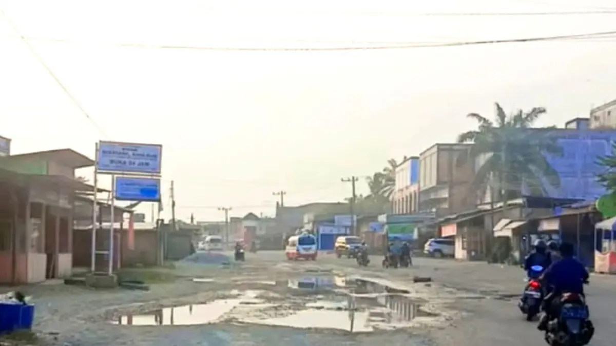 Pengendara menghindari titik jalan rusak dan berlubang yang tergenang air saat melintasi ruas jalan provinsi di Desa Ujung Batu Timur, Kecamatan Ujung Batu, Rohul, Jumat (28/8/2026). (Warga Ujung Batu untuk Riaupos.co)