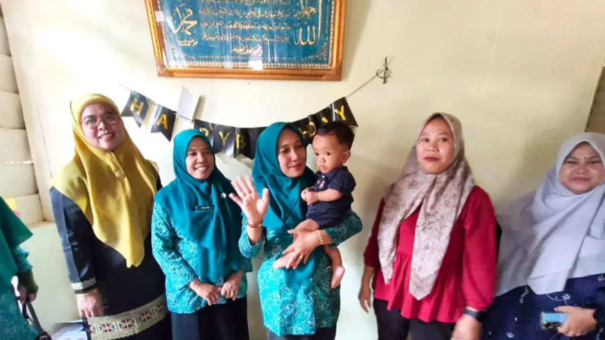 Plt TP PKK Kuansing Hj Nurhidayah Muniroh bersama pengurus dan anak stunting saat menyerahkan bantuan, Jumat (28/8/2026). (Istimewa)