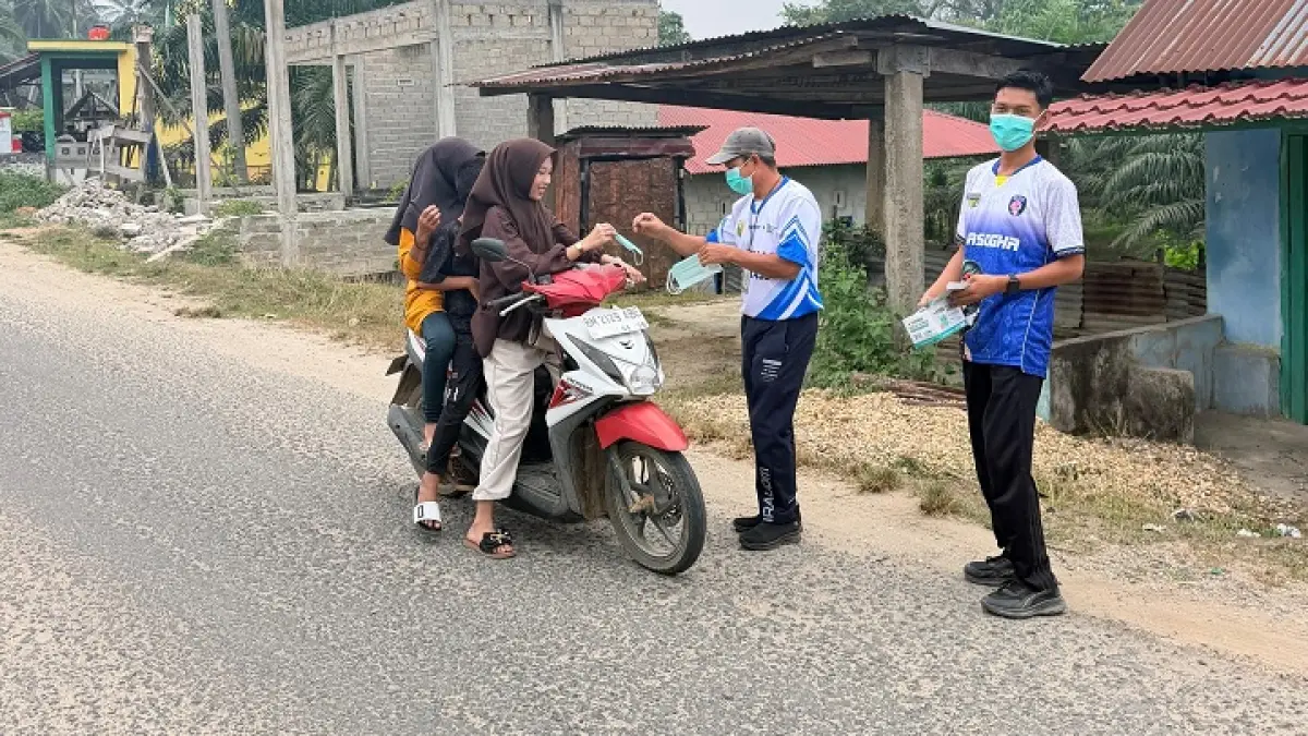 Petugas Puskesmas Kotorajo Kecamatan Kuantan Hilir Seberang, membagikan masker pada pengguna jalan, Sabtu (29/8/2026). (Diskes Kuansing)