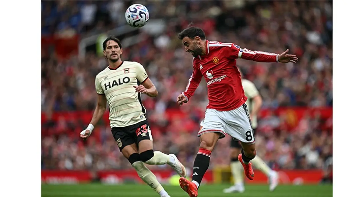 Gelandang Ipswich Town  Sasa Lukic (kiri), berduel dengan gelandang Manchester United  Bruno Fernandes (kanan), dalam pertandingan Liga Premier di Old Trafford, Manchester, Senin (31/8/2026). (Paul ELLIS/AFP)