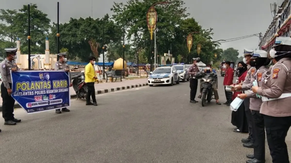 Satlantas Polres Kuansing bagi-bagi masker pada pengguna pengendara di Jalan Sudirman Teluk Kuantan, Selasa (1/9/2026). (Desriandi Candra/Riaupos.co)