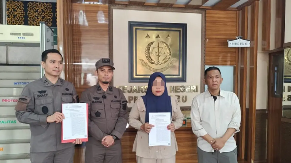 Herawati (perempuan) menerima surat penghentian perkaranya dari Kasi Pidum Kejari Pekanbaru Marulitua Johannes Sitanggang (dua dari kiri), di Kejari Pekanbaru pada Rabu (2/9/2026). (Hendrawan Kariman/Riaupos.co)