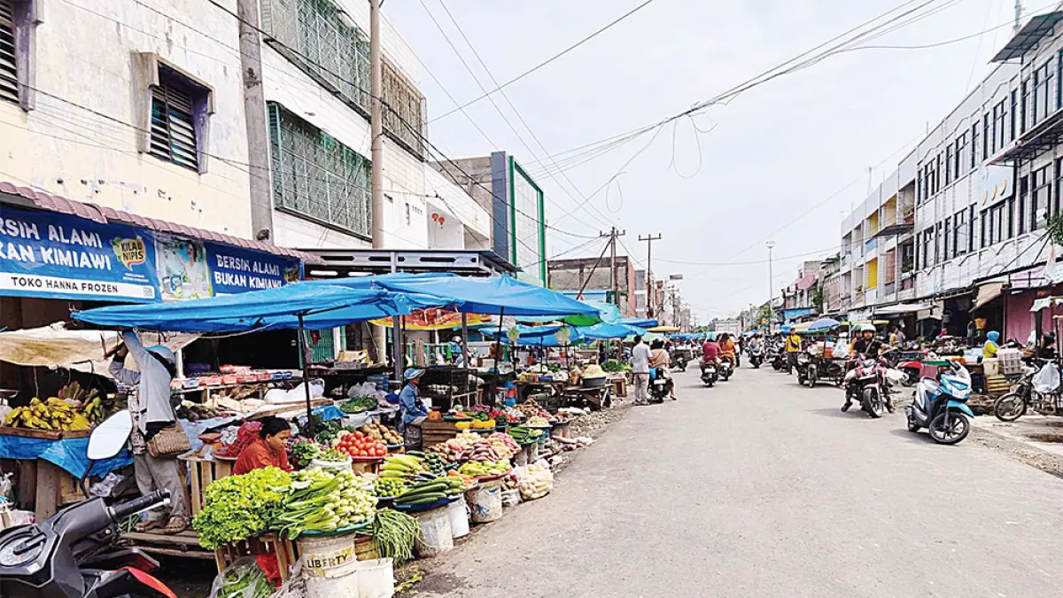 JUALAN DI ATAS DRAINASE: Sejumlah pedagang masih nekat berjualan di atas drainase Jalan Teratai, Kota Pekanbaru yang baru selesai diaspal, Selasa (1/9/2026). Pemko Pekanbaru diminta segera menata pedagang di Jalan Teratai. (EVAN GUNANZAR/RIAU POS)