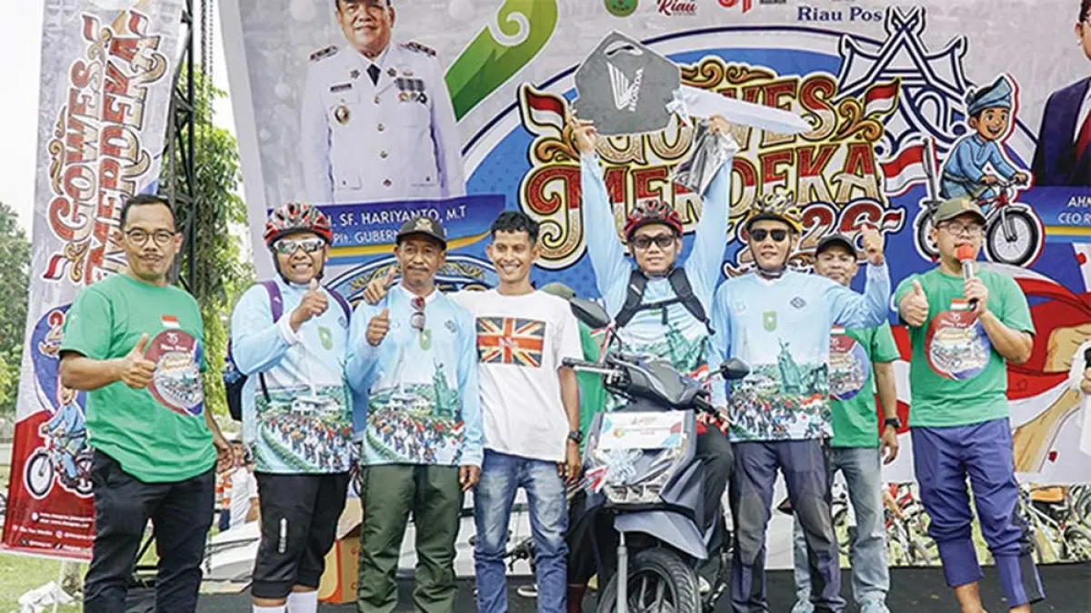Direktur Utama Riau Pos Ahmad Dardiri (kanan) didampingi Direktur Riau Pos Asmawi Ibrahim (kiri) berpose bersama Sarbaini (empat kanan) peraih hadiah utama Riau Pos Gowes Merdeka 2026 berupa sepeda motor di halaman kantor Gubernur Riau, Ahad (30/8/2026).MHD AKHWAN/RIAU POS