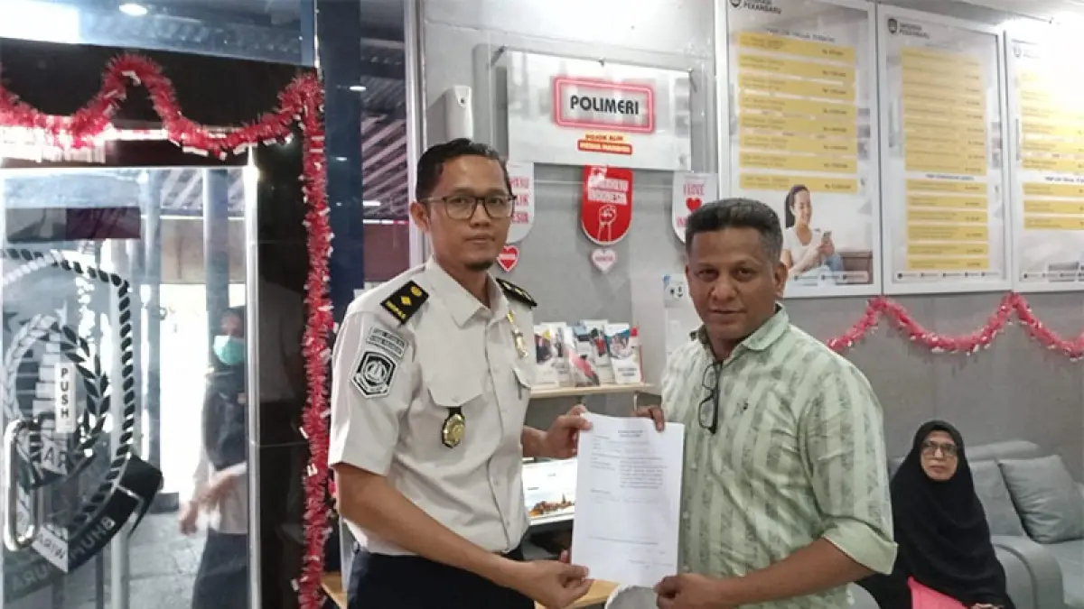 Kasi Izin Tinggal dan Status Keimigrasian Kantor Imigrasi Kelas I TPI Pekanbaru Muhammad Hidayat menyerahkan dokumen kepada WNA yang memanfaatkan layanan dengan dukungan Polmeri, baru-baru ini. Humas Imigrasi Pekanbaru