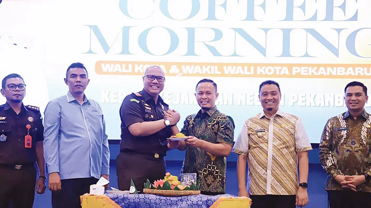BERI TUMPENG: Wali Kota Pekanbaru Agung Nugroho didampingi Wawako Pekanbaru Markarius Anwar memberikan potongan tumpeng pada Kajari Pekanbaru Carel Williams saat coffee morning, Kamis (3/9/2026) di Aula Lantai VI Gedung Utama Perkantoran Wali Kota Pekanbaru. (Diskominfotik pekanbaru untuk riau pos)

