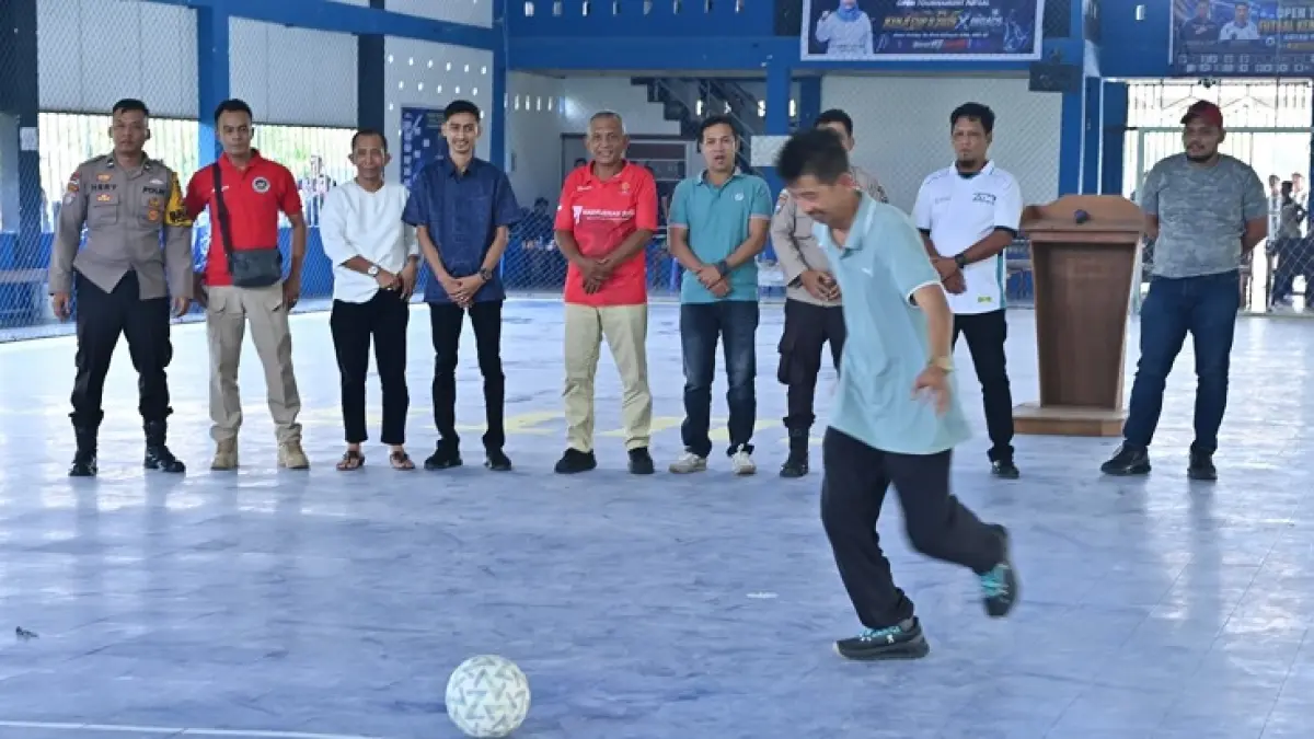 Staf Ahli Bupati Bengkalis Johansyah Syafri menendang bola perdana dalam resmi turnamen futsal di Lapangan Futsal Kenji, Jalan Baru Desa Wonosari, Ahad (6/9/2026).(Istimewa)