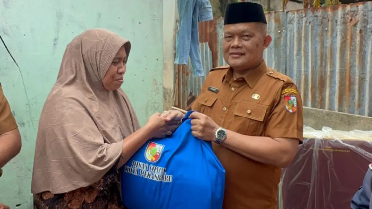 Kepala Dinas Sosial Kota Pekanbaru, Junaedy, bersama jajaran Bidang Perlindungan dan Jaminan Sosial saat menyerahan bantuan. (Istimewa)