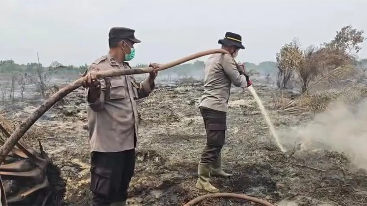 Petugas Polres Bengkalis melakukan pemadaman dan pendinginan yang sudah memasuki hari ketiga, di areal HGU PT Teguh Karsa Wana Lestari (TKWL), Desa Bandar Jaya, Siak Kecil, Bengkalis, Senin (7/9/2025). Foto Istimewa
