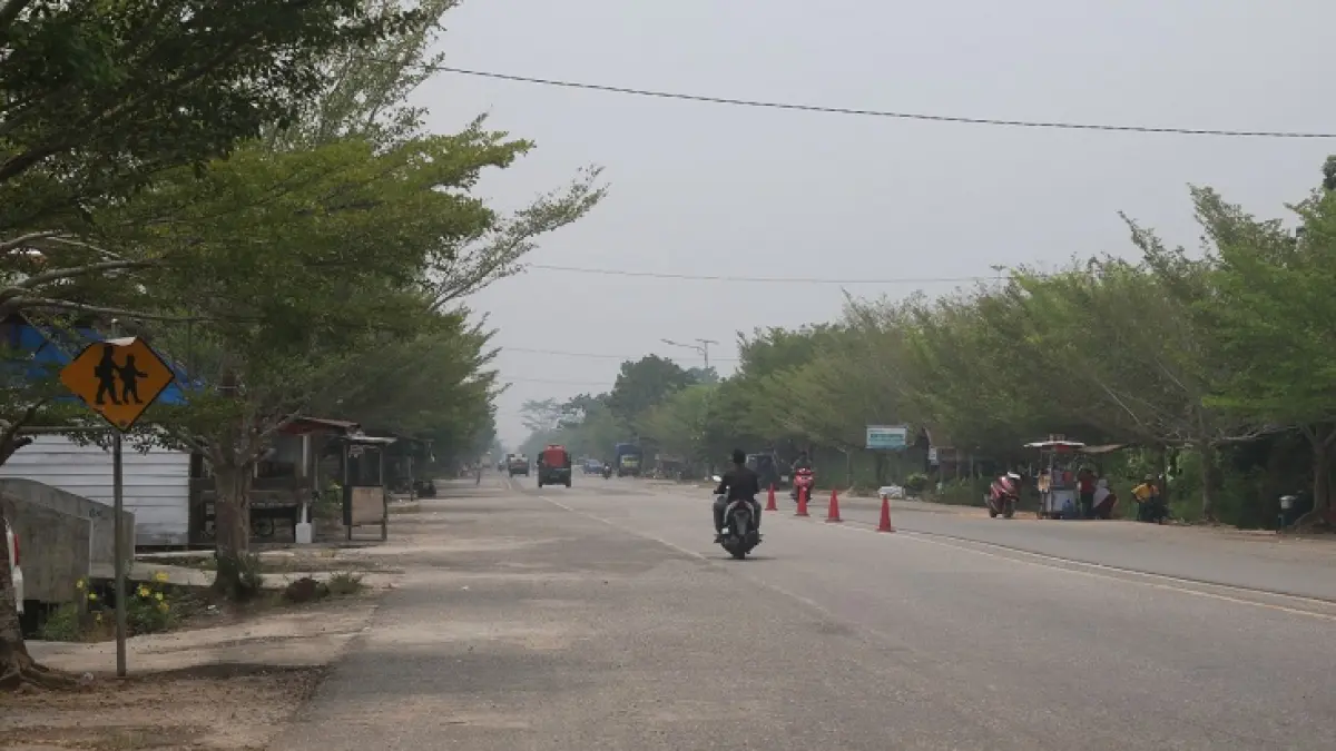 Kondisi di jalan lintas Bagansiapiapi-Ujung Tanjung diselimuti kabut asap tipis, Rabu (9/9/2026).(Zulfadhli/Riaupos.co)