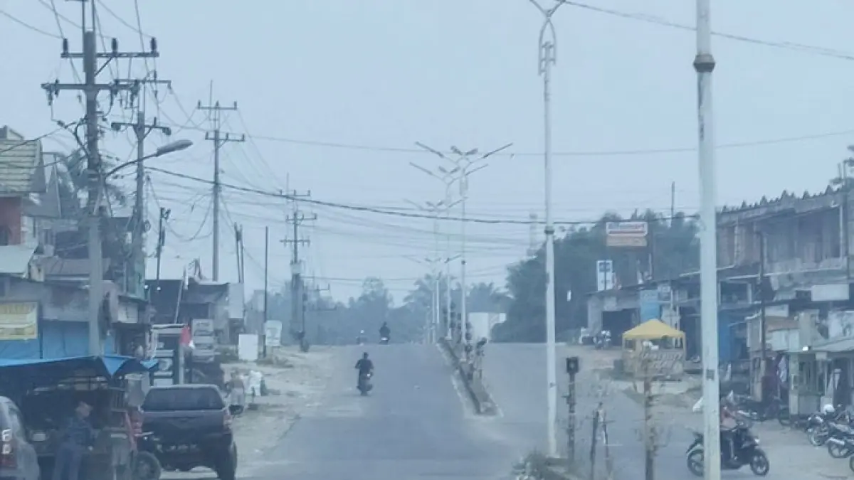 Kondisi kabut asap terlihat pekat di ruas jalan provinsi di Pasar Kabun, Kecamatan Kabun, Rohul, Rabu (9/9/2026) siang. (Engki Prima Putra/Riaupos.co)