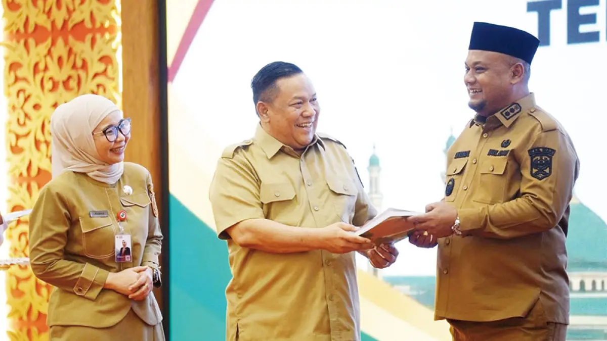 Pelaksana Tugas Gubernur Riau SF Hariyanto menyerahkan data tunggakan pajak kepada Wakil Bupati Siak Syamsurizal di Gedung BRKS, Pekanbaru, Selasa (8/9/2026). (Diskominfotik Riau&nbsp;untuk Riau Pos)