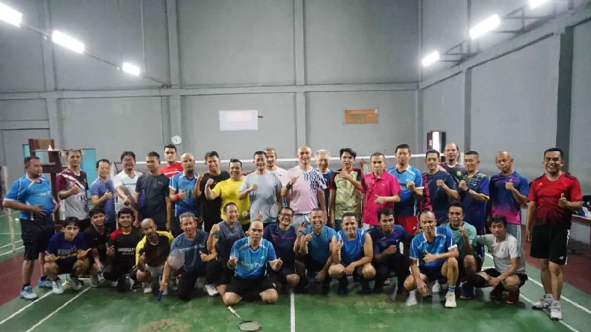 Dirut Riau Pos Ahmad Dardiri (berdiri empat kiri) serta tim bulu tangkis Riau Pos foto bersama PB UIN Suska Riau saat melakukan pertandingan persahabatan di GOR Panam Jaya Pekanbaru . Kamis (10/9/2026). (Evan Gunanzar/Riaupos.co)