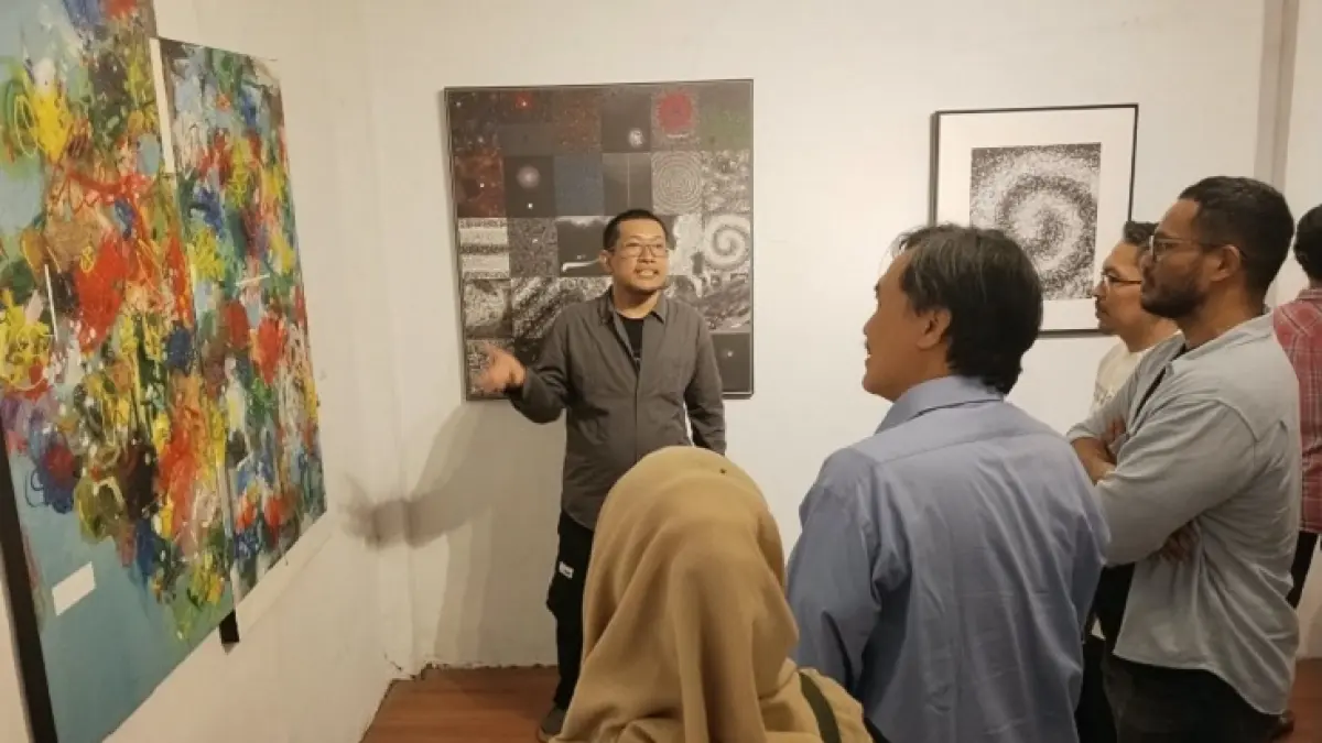 Perupa Cak Winda saat menjelaskan konsep karyanya pada pengunjung pameran. (GHN untuk Riau Pos)