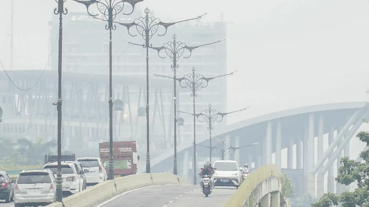 Kendaraan melintasi flyover di Jalan Jenderal Sudirman saat kabut asap masih menyelimuti Kota Pekanbaru, Rabu (16/9/2026). (MHD AKHWAN/RIAU POS)