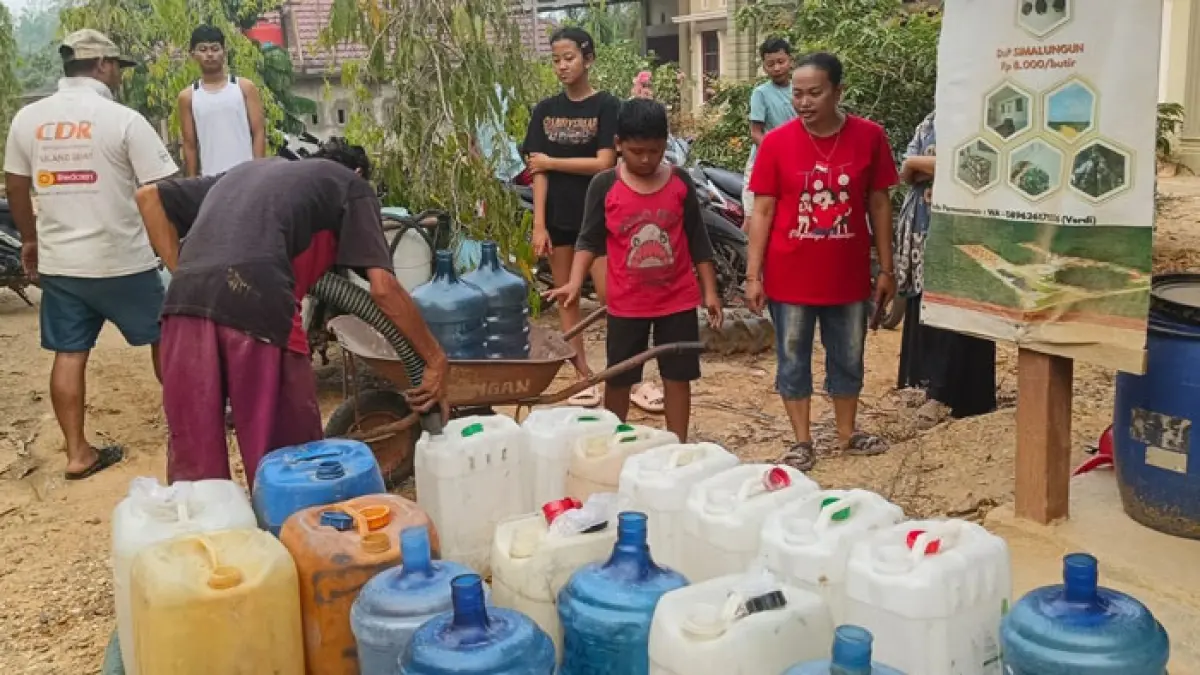 Warga Desa Bukit Petaling mengisi jeriken dengan air dari tangki PDAM, Kamis (17/9/2026). (Kasmedi/Riaupos.co)