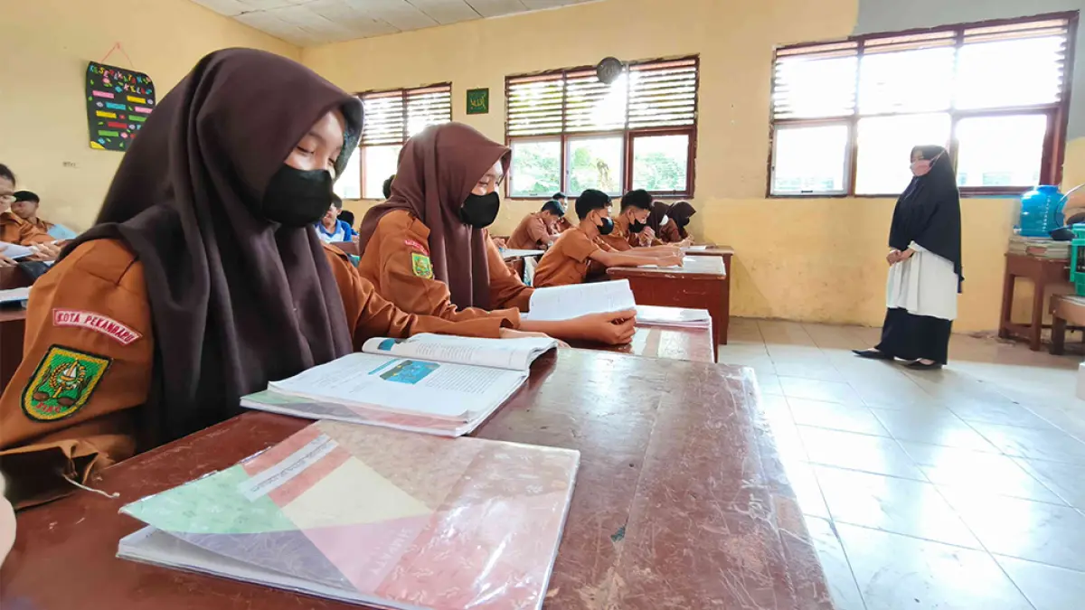 PAKAI MASKER: Para pelajar SMPN 20 Pekanbaru belajar di dalam kelas dengan tetap memakai masker, Rabu (23/9/2026).(evan gunanzar/riau pos)