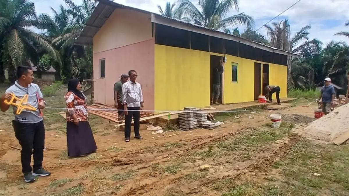 Guru kelas jauh SDN 007 Sungai Agung Rohmawati saat mendampingi Plt Kadisdikpora Helmi mengukur lahan sekolah, Kamis (24/9/2026). (Kamaruddin/Riaupos.co)