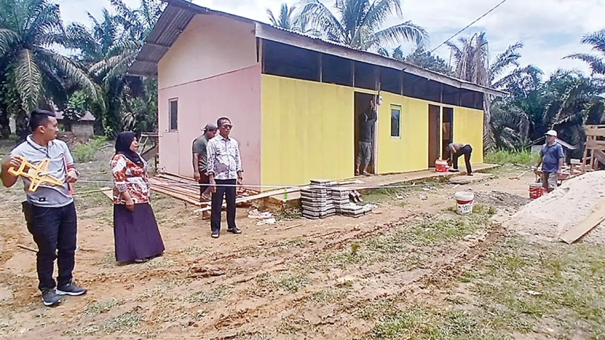 Perwakilan Disdik Kampar mengukur lahan yang akan dibangun gedung baru untuk peserta kelas jauh UPT SDN 007 Desa Sungai Agung, Kecamatan Tapung, Kabupaten Kampar, Kamis (24/9/2026). Tampak gedung lama berdiri dengan dinding tripleks.(DISDIKPORA KAMPAR UNTUK RIAU POS)