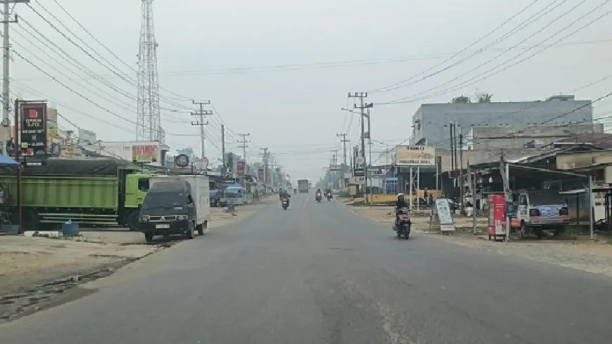 Kabut asap terlihat di Jalan Lintas Timur Kelurahan Pematang Reba Kecamatan Rengat Barat, Selasa (29/9/2026).(Raja Kasmedi/Riaupos.co)