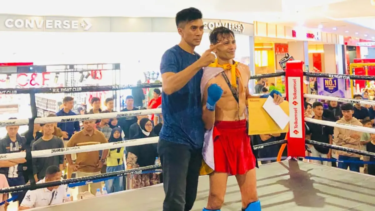 Atlet Siwalima Muaythai Bengkalis, Yukai Martin didampingi Pelatih Muaythai provinsi Riau, Sinyo Lesnussa usai tampil dominan dan berhasil mengandaskan atlet andalan tuan rumah, Farhan Omar, pada partai puncak (Main Event) ajang Dumai Betumbuk 2026. (Istimewa)