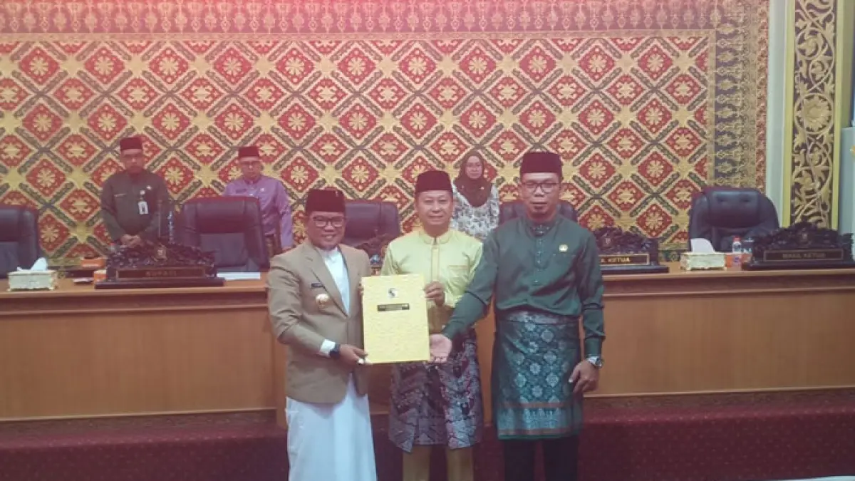 Bupati Pelalawan, H Zukri menyerahkan Berita Acara pengesahan kepada Ketua DPRD Pelalawan, H Syafrizal SE didampingi Wakil Ketua II, Tengku Azriwardi ST usai menggelar pengesahan Ranperda&nbsp;APBD-P&nbsp;2026, Rabu (30/9/2026) sore di gedung DPRD Pelalawan. (Amin/Riaupos.co)