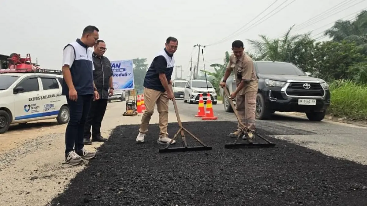Direktur Bisnis BRI Finance Primartono Gunawan (tengah), didampingi Corporate Secretary Group Head PT. BRI Multifinance Indonesia Aditia Fakhri Ramadhani (kiri) bersama Nanda Ladio Peduli (kanan) melakukan perbaikan jalan Pesantren Kecamatan Bukit Raya, Rabu (7/10/2026).(BRI Finance for Riau Pos)
