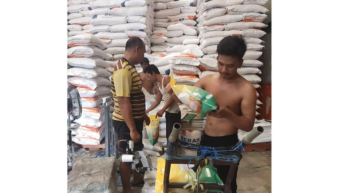 Para pekerja di gudang Bulog Damun, Kecamatan Bengkalis mengisi beras ke dalam kemasan 5 kg SPHP, beberapa waktu lalu. (abu kasim/riau pos)