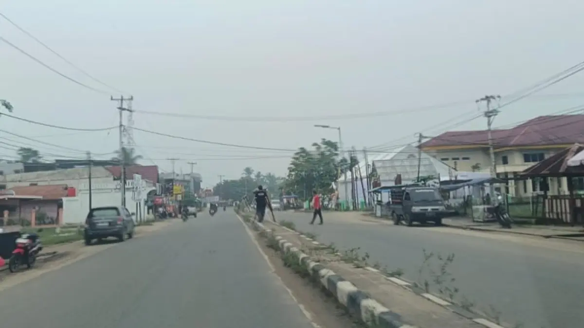 Kabut asap terlihat tebal di Jalan Sudirman Air Molek Kecamatan Pasir Penyu, Ahad (11/10/2026). (Kasmedi/Riaupos.co)