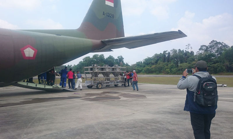 MASUKKAN KONSOL: Petugas sedang memasukkan konsol atau alat penyemai garam ke dalam pesawat sebelum terbang di Lanud Roesmin Nurjadin, Pekanbaru, Sabtu (28/9/2019). (HELFIZON ASSYAFEI/RIAU POS)