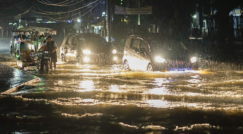TEMBUS BANJIR: Pengendara berusaha menembus banjir yang terjadi di persimpangan jalan layang Pasar Pagi Arengka, Kota Pekanbaru, Selasa malam (11/6/2019). Hujan dengan durasi panjang ini membuat sejumlah kawasan di Jalan HR Soebrantas tergenang sehingga b