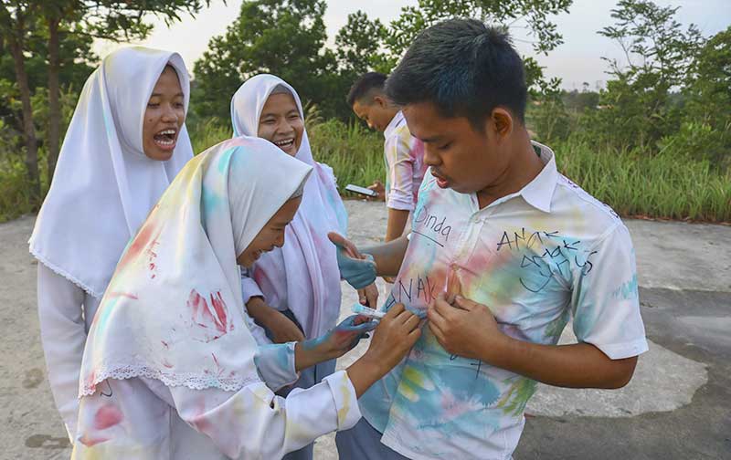 CORET BAJU: Sejumlah siswa SMA/SMK melakukan aksi coret baju usai mengetahui pengumuman kelulusan di kawasan Stadion Utama  Riau, Pekanbaru, Senin (13/5/2019). (EVAN GUNANZAR/RIAU POS)