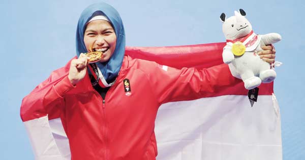 GIGIT EMAS: Defia Rosmaniar menggigit medali emas yang diraih setelah menang atas atlet Iran Marjan Salahshouri pada nomor poomsae cabang taekwondo Asian Games 2018 di Jakarta, Ahad (19/8/2018). Defia mempersembahkan emas pertama untuk kontingen Indonesia
