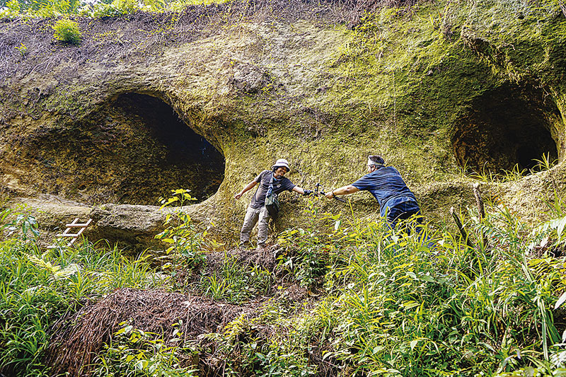 MULUT GUA: Riau Pos mencoba melewati tebing di antara dua mulut gua yang berada di belakang rumah seorang warga Batu Besurat, Kecamatan XIII Koto Kampar,  di tepi jalan lintas Riau-Sumbar, akhir pekan lalu.(Mohammad Akhwan/riau pos)