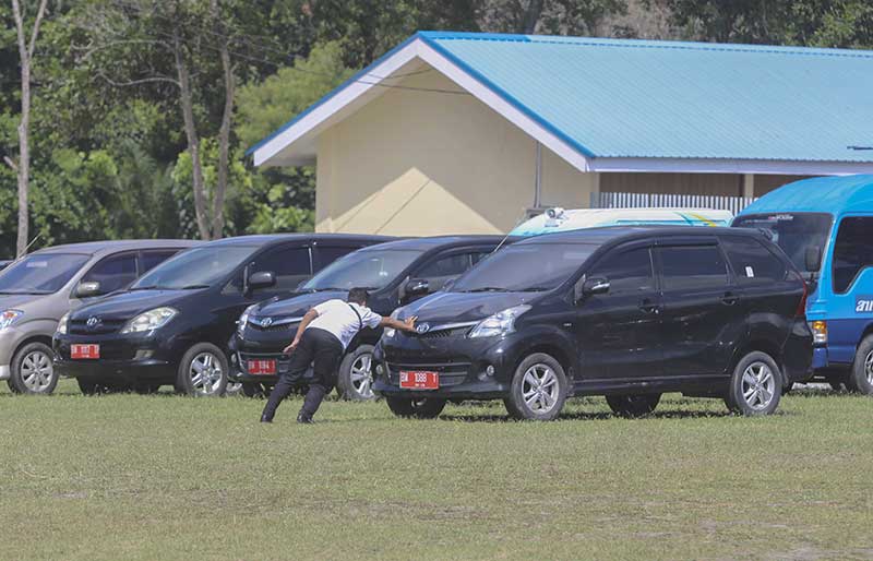 DORONG MOBIL: Pegawai Pemprov Riau mendorong mobil dinas yang diinapkan di halaman belakang kediaman Gubernur Riau di Jalan Diponegoro, Pekanbaru, Senin (10/6/2019). Kendaraan dinas ini diinapkan agar tidak disalahgunakan ASN untuk kepentingan di luar din